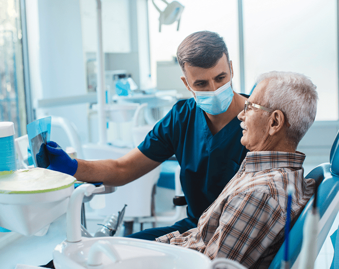 Dentist in mask examining senior patient in modern dental clinic office