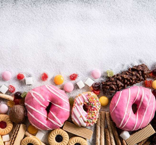 Colorful donuts and candy illustrate how sugary foods impact children's dental health and tooth decay.